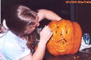 Karen scooping pumpkin guts from her creation